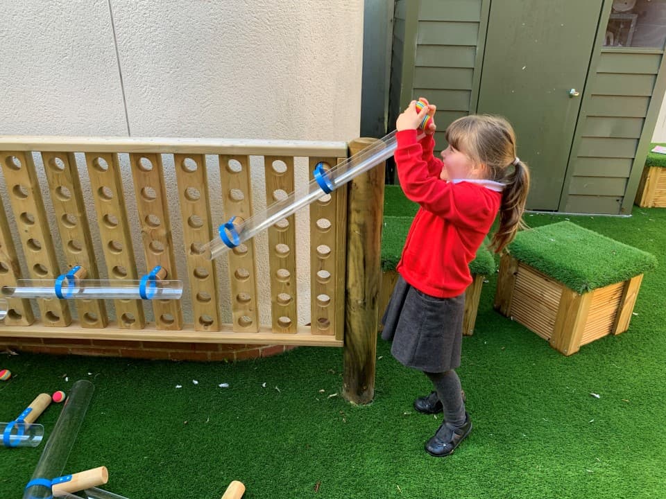 a little girl using the ball run