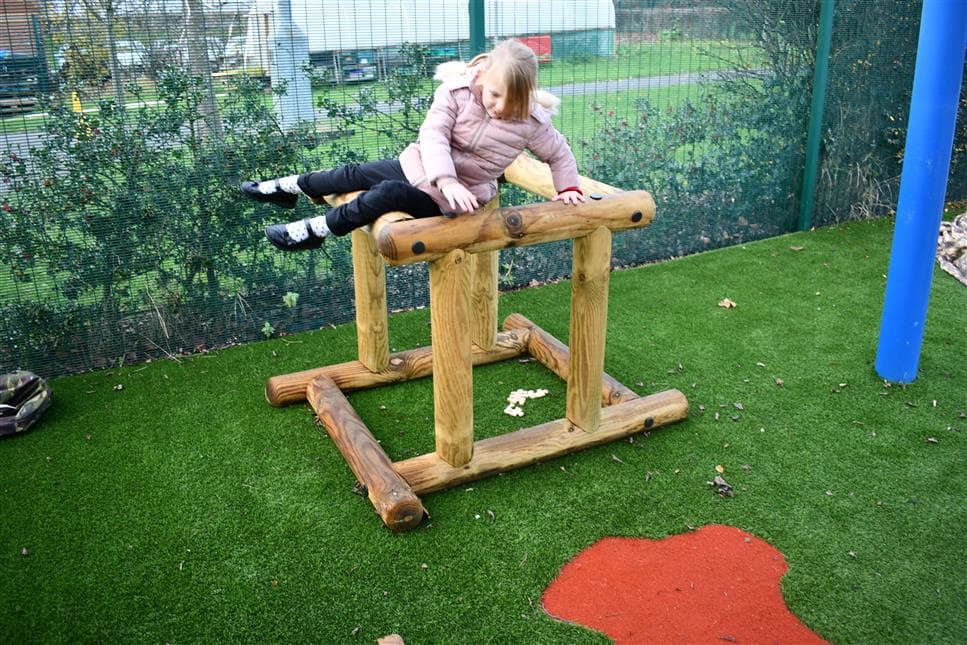 A young girl playing ono the in and out shape in her playground 