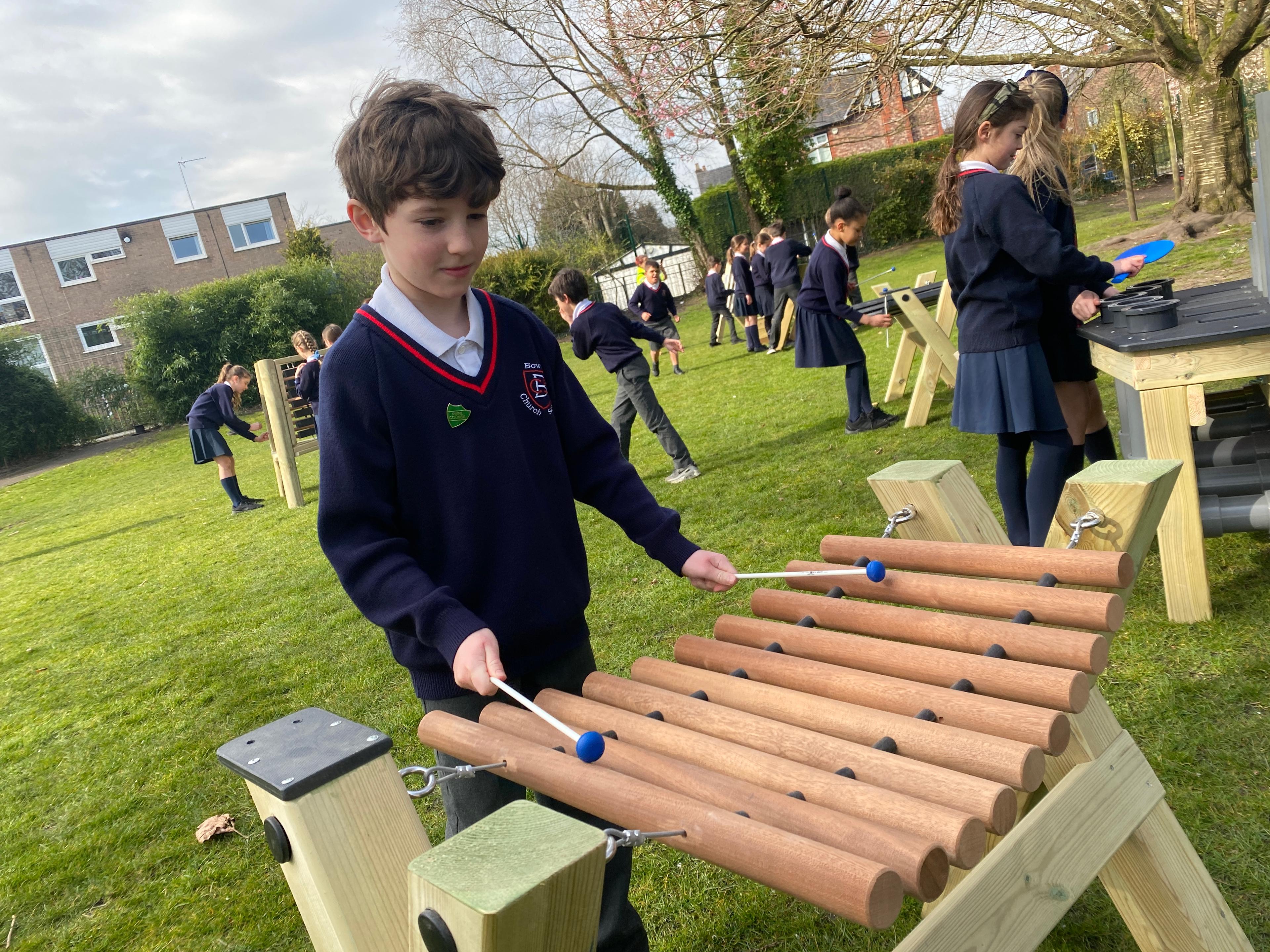a young boy playing on the marimba on his playground