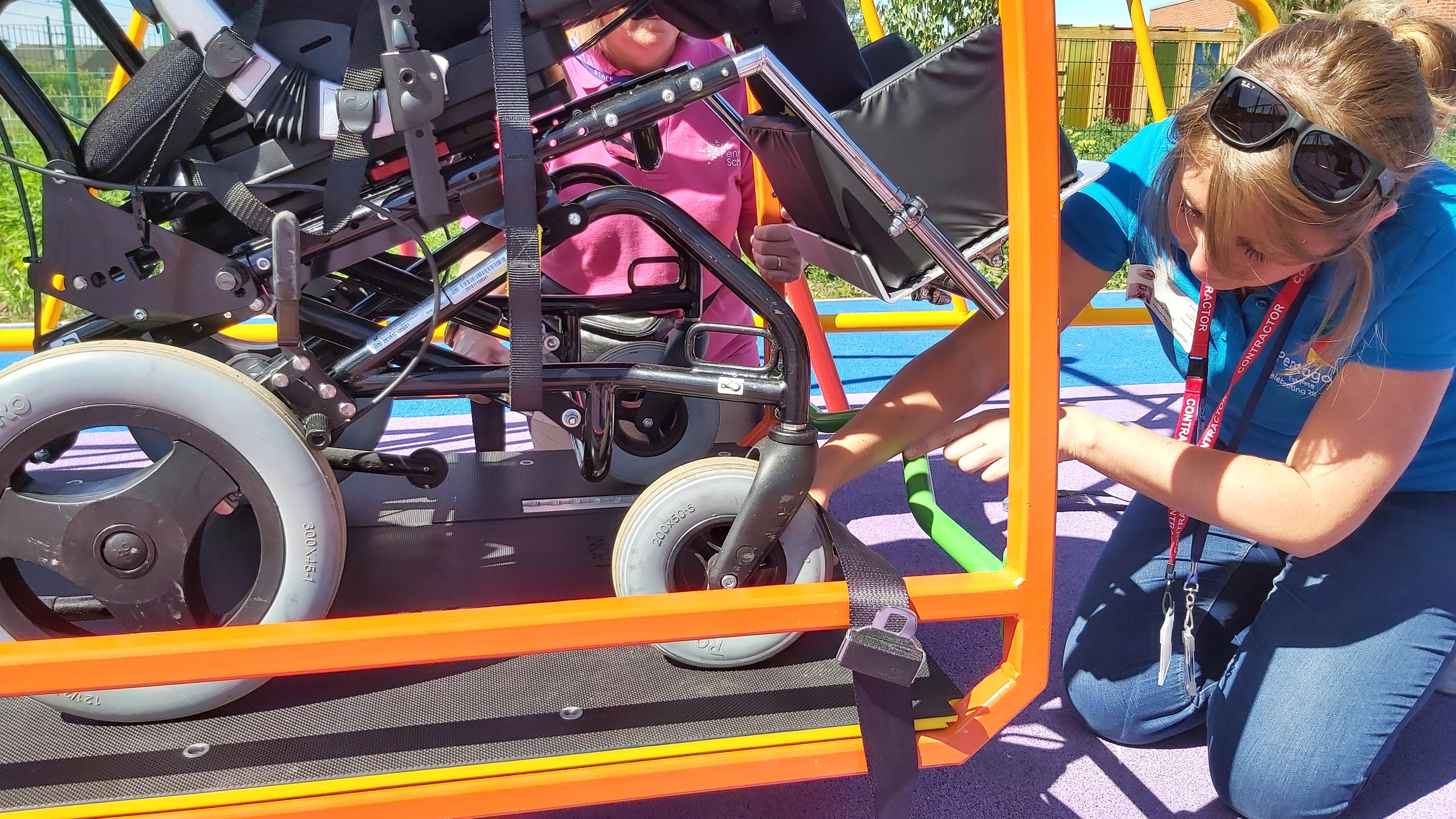 a wheel chair being strapped into the wheelchair swing
