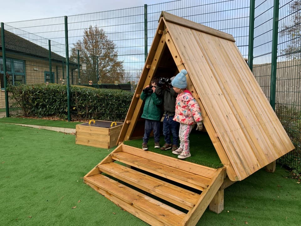forest floor learning den with window and bench