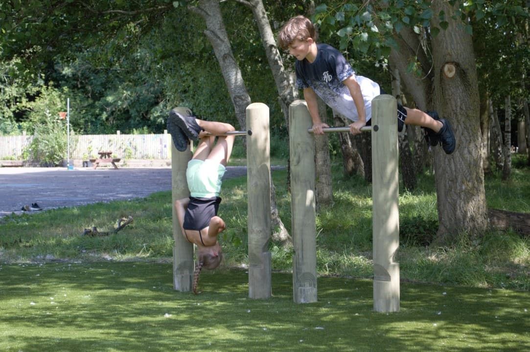 two children flipping over the rollover bars