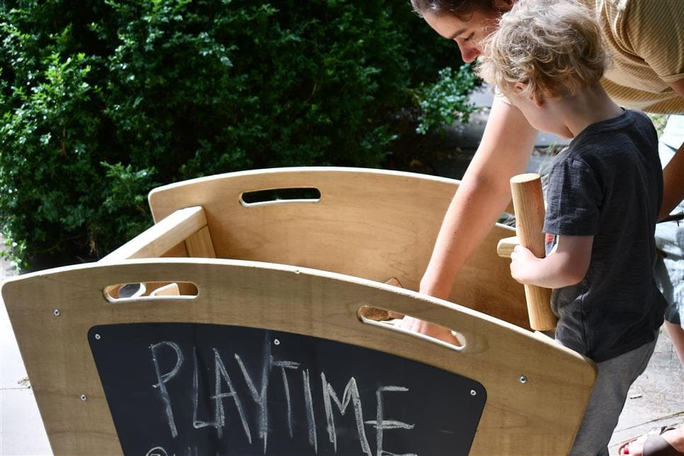A young boy reaching into the skip to get some blocks out