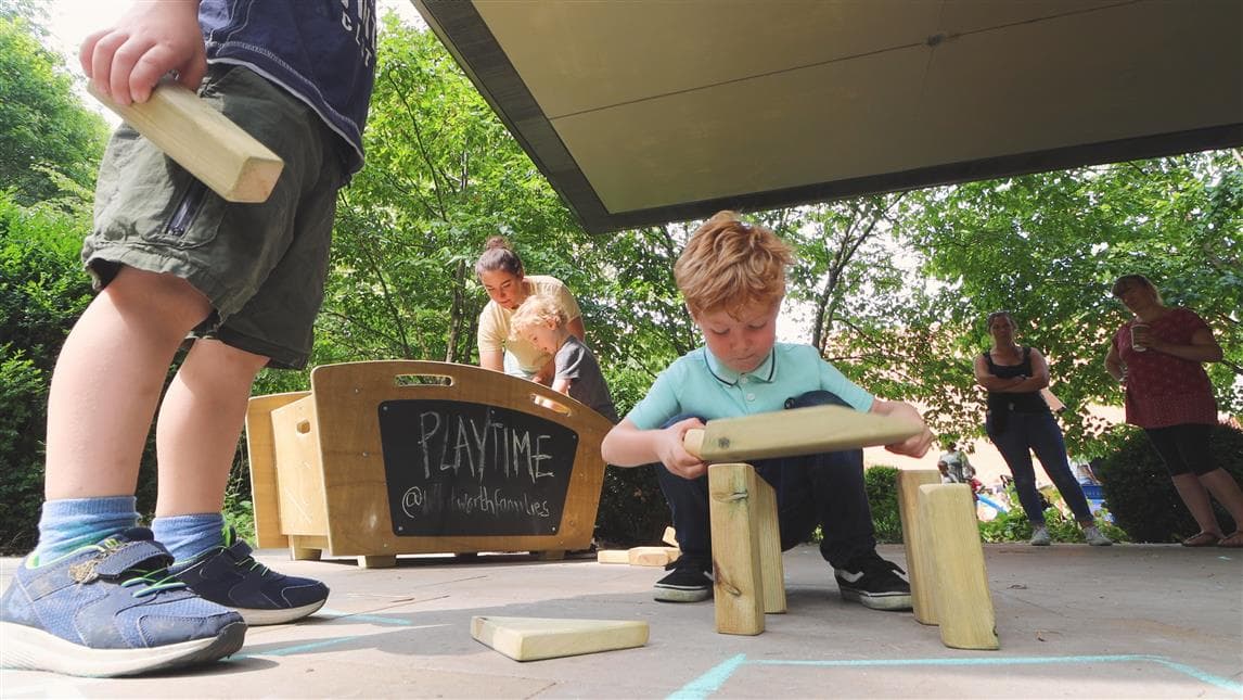 A close up shot of a young boy playing with the blocks from the construction skip 