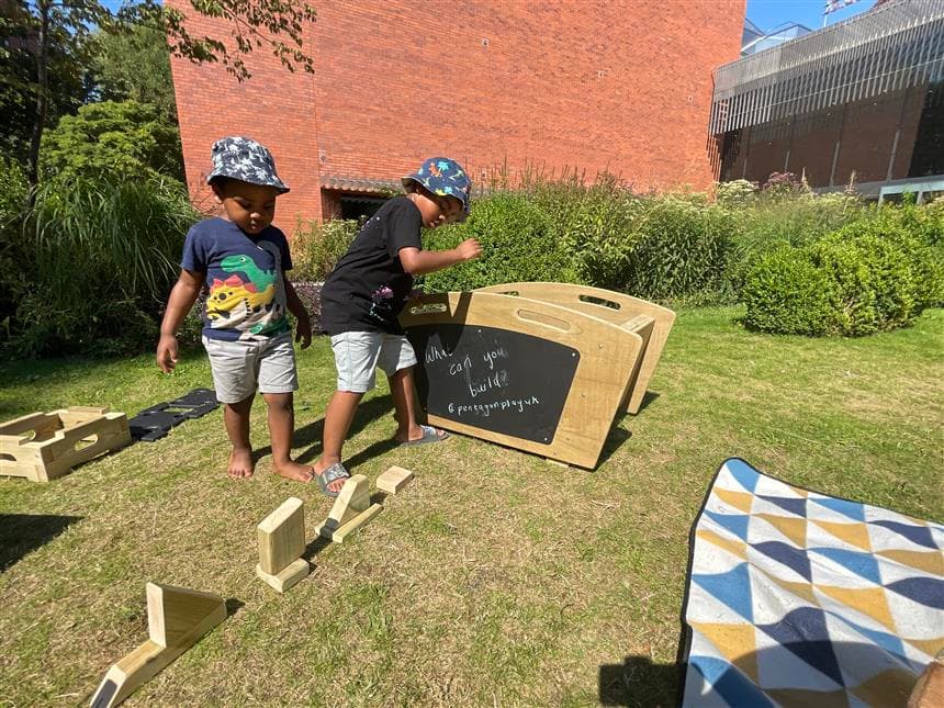 2 young boys playing with the blocks in front of the construction play skip