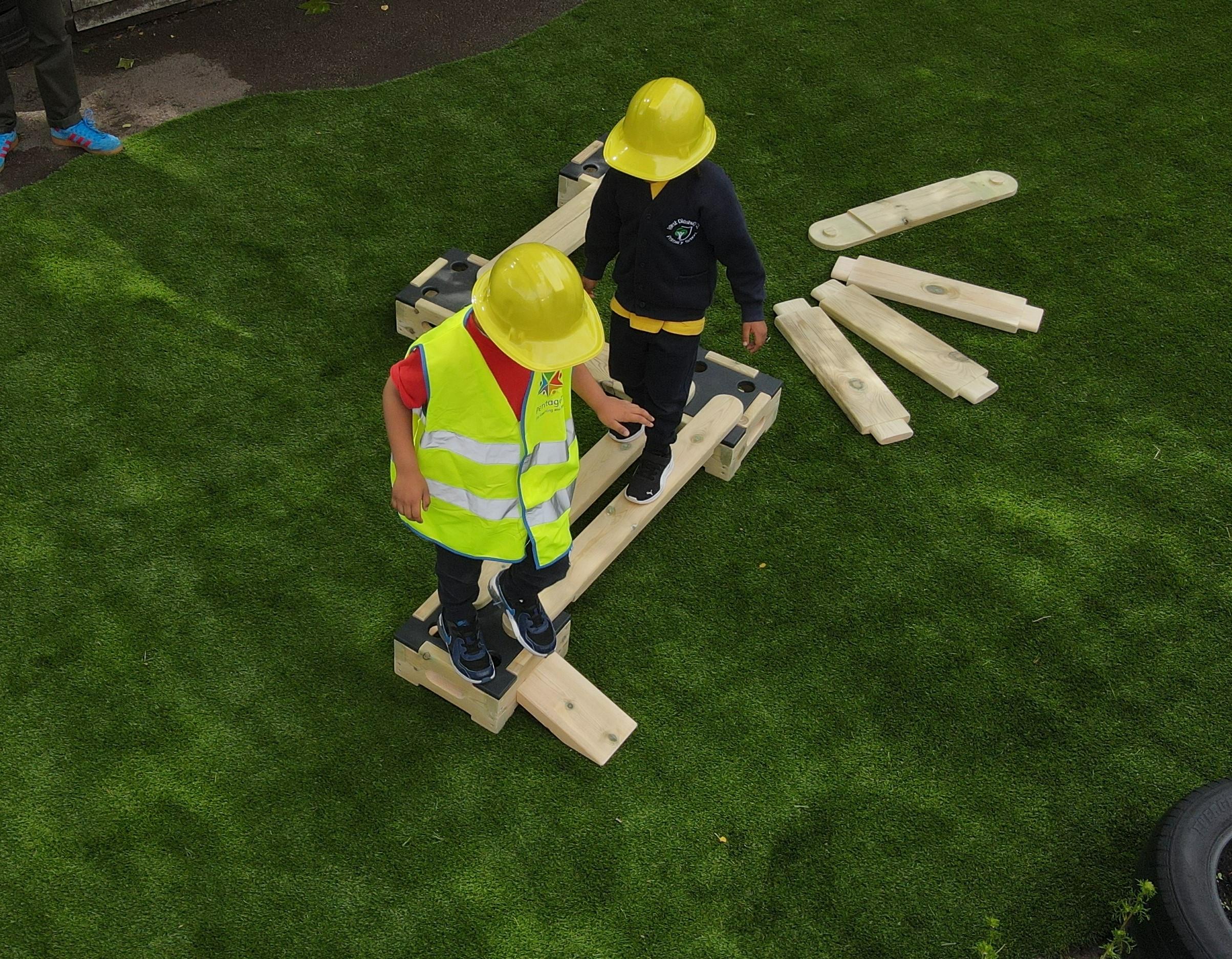 two children walking across the play builder