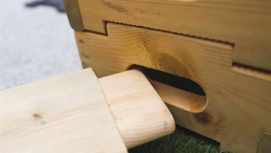 A plank slotting into the hole on the play builder