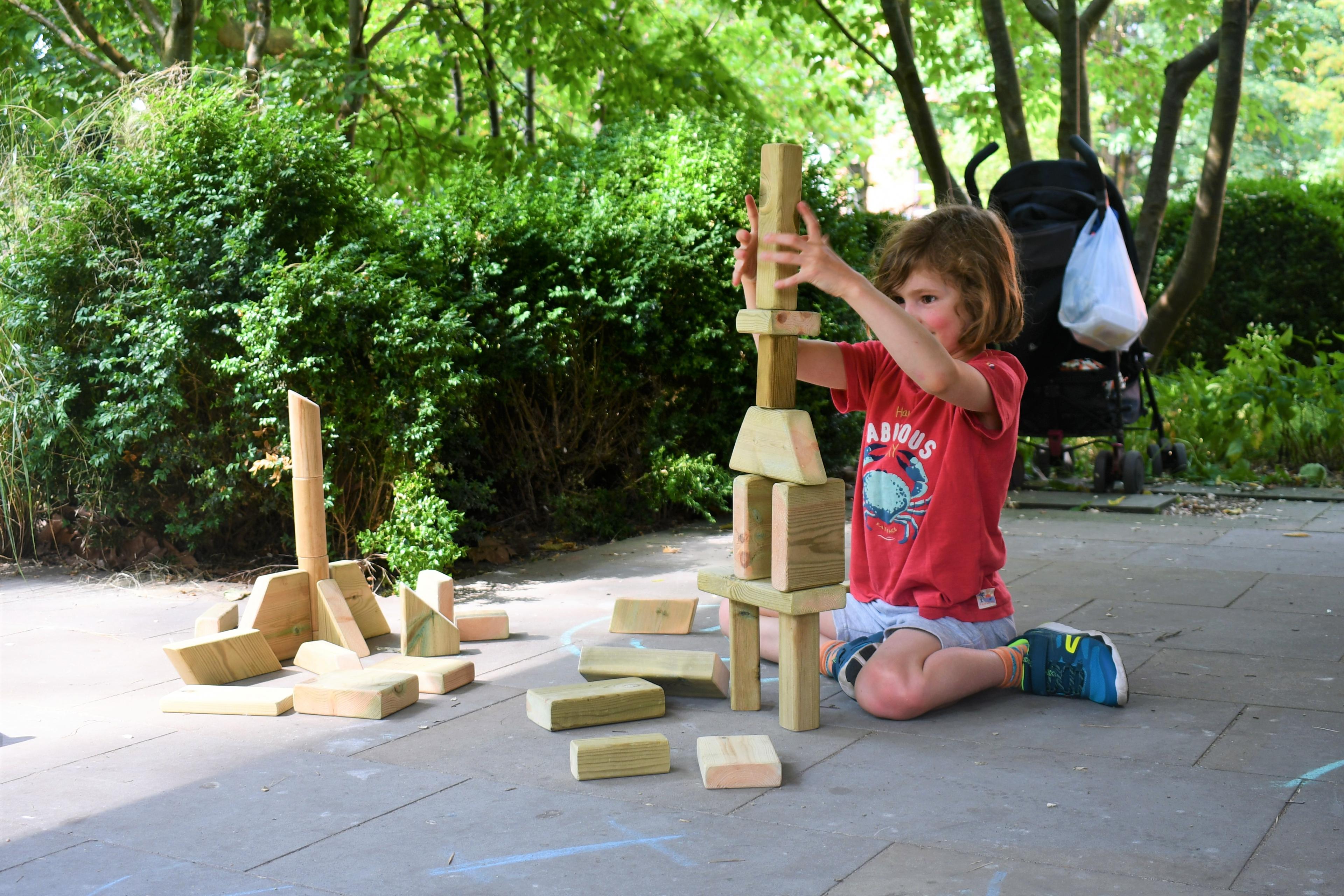 A young boy playing with the blocks from the mini skip