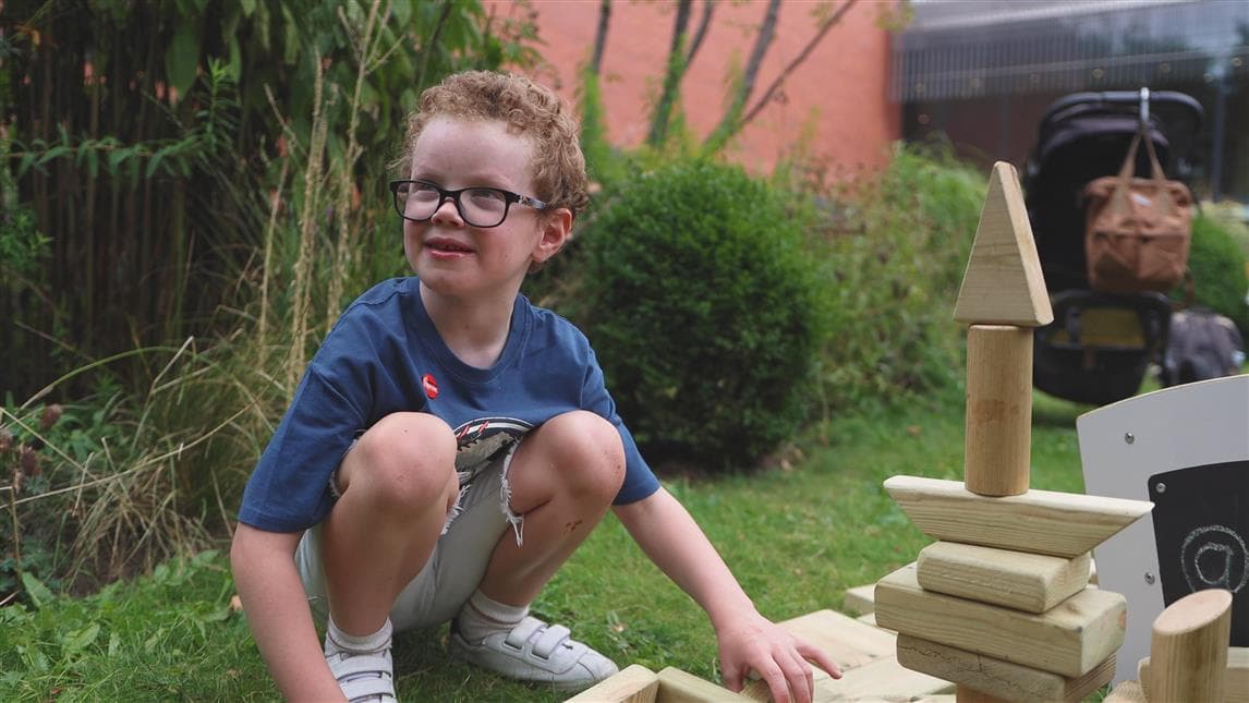 A young boy playing with the blocks from the mini skip