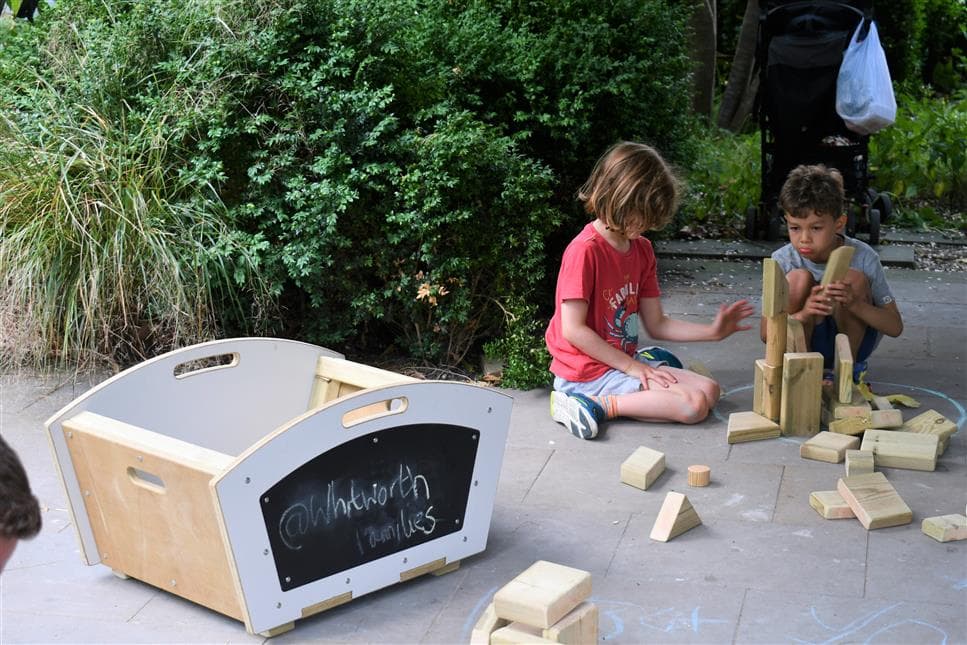 2 young boys playing with the blocks from the construction mini skip 