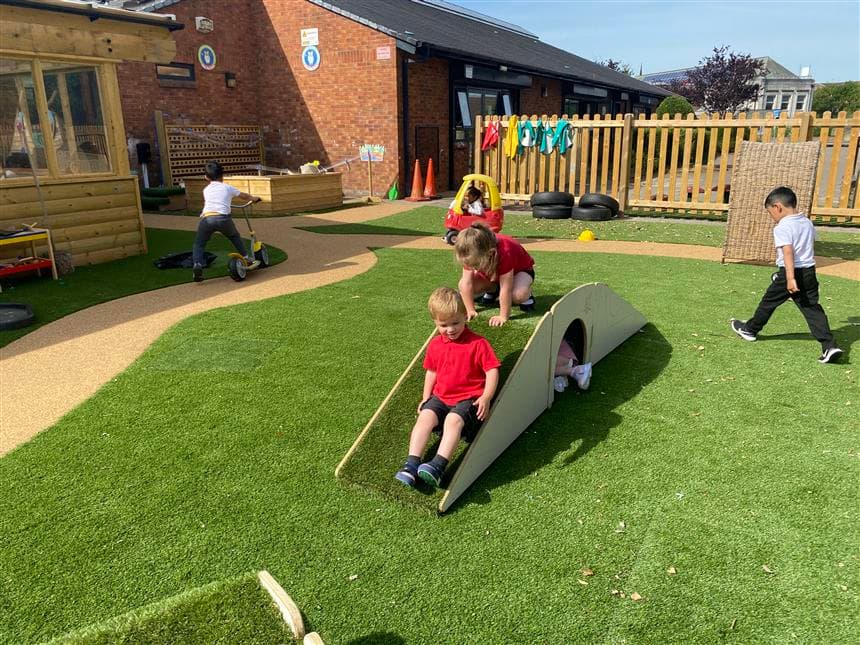 2 children climbing over the locks and one young girl is climbing through the tunnel