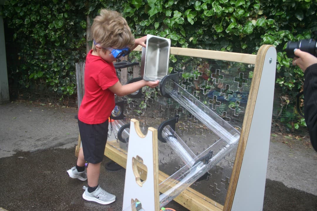 Children can channel the water along the channels from the water wall and into the freestanding stands