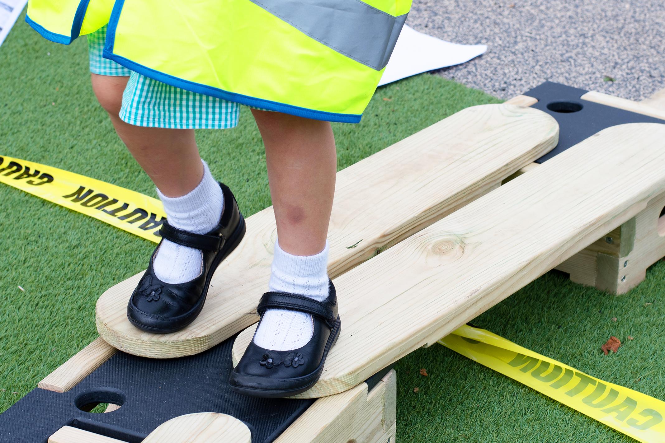 A close up photo of one of the Accoya planks with a child stood on top of it. The Play Builder Technician Set is made out of Accoya wood and the photo aims to highlight this fact.