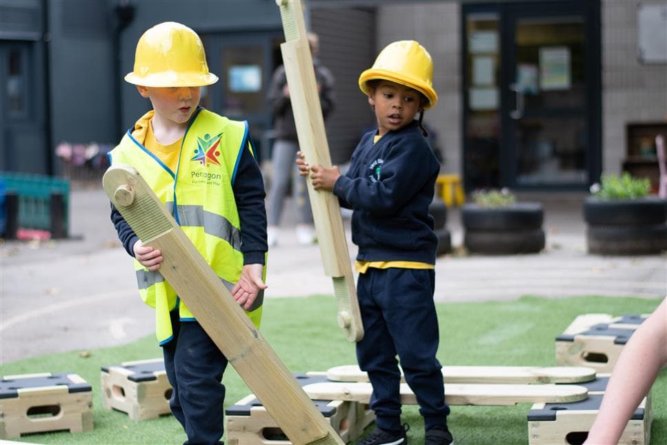 2 children walking with planks from the play builder
