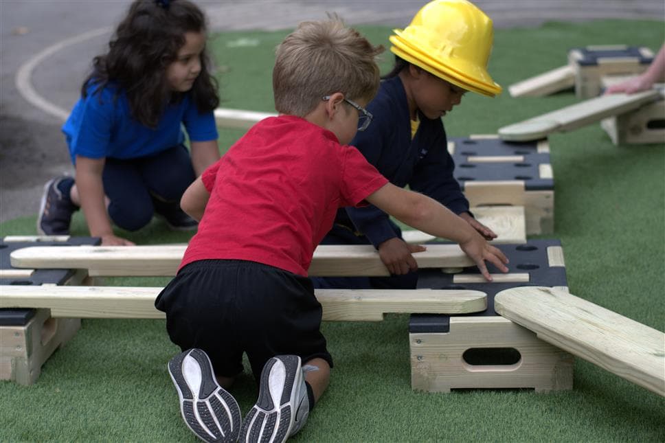 3 children working together to put the planks into the blocks