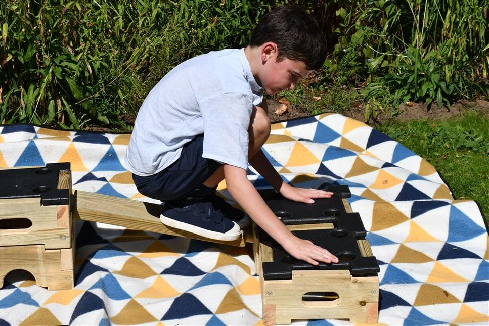 A young boy placing the plank in the play builder
