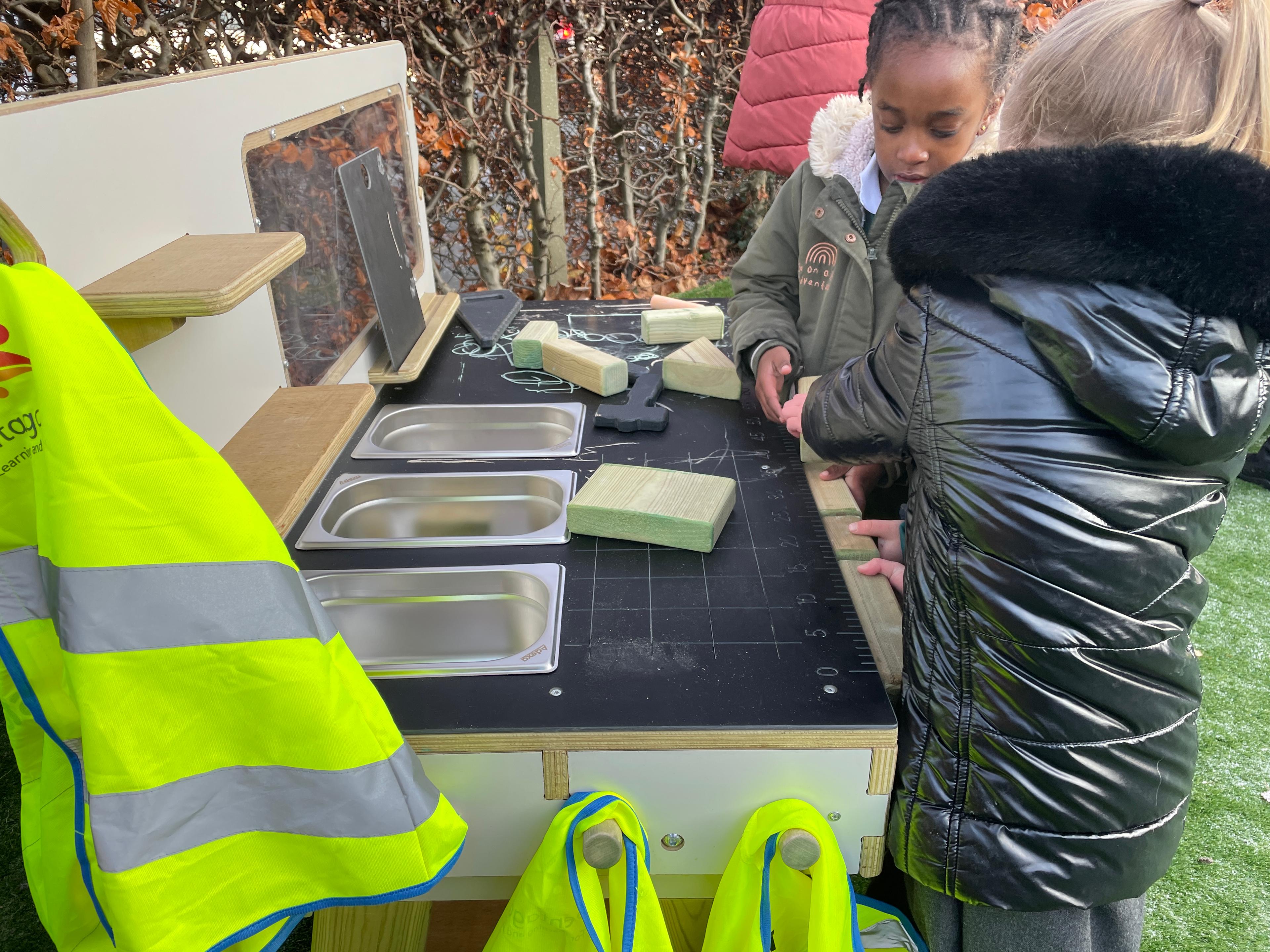 2 young girls playing on the construction table in their eyfs setting