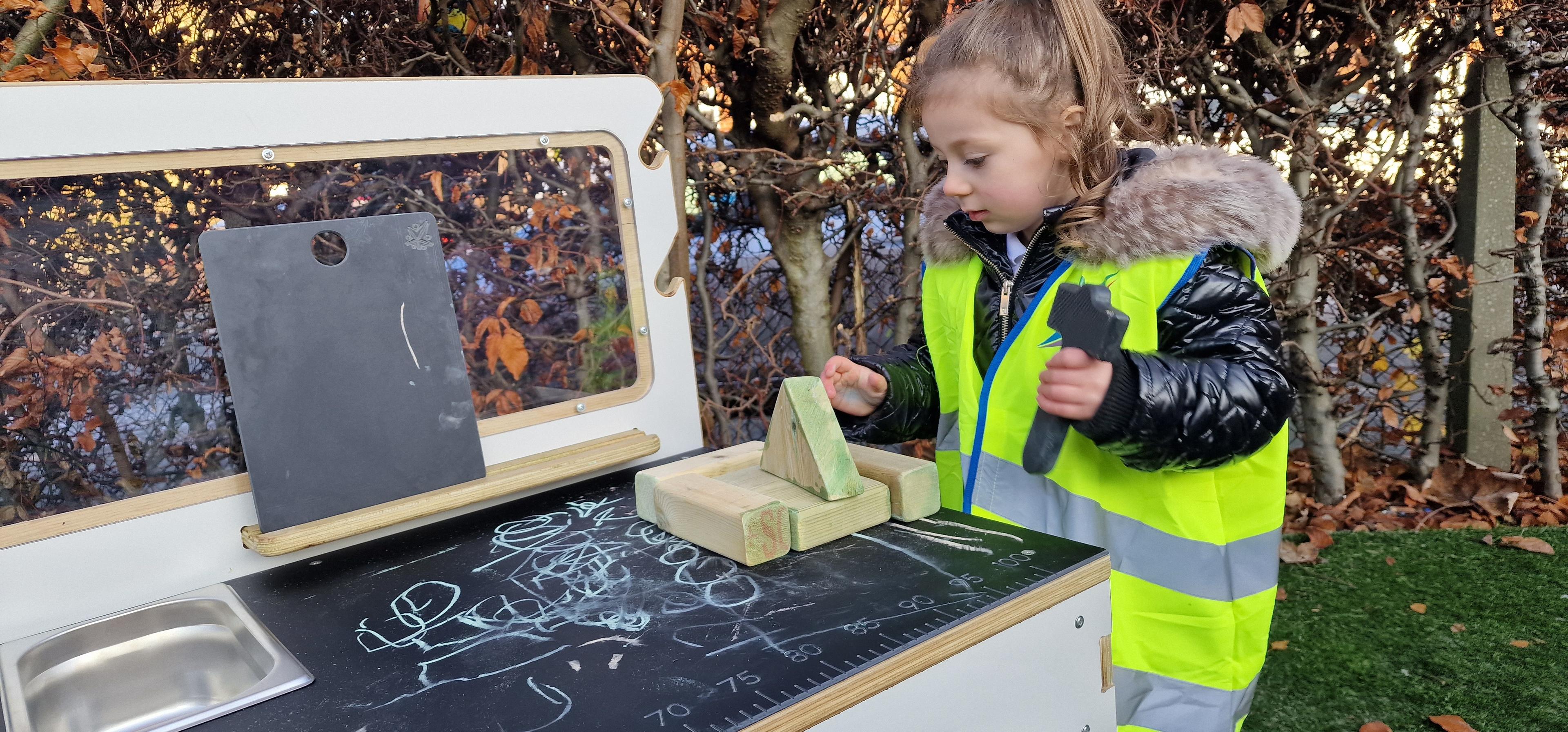 A young girl playing on a construction table in her primary school