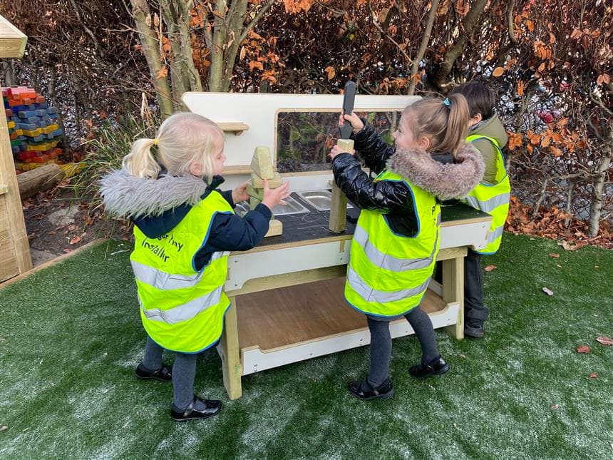 A group of eyfs children playing on the construction table