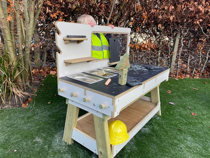 A young girl playing on the construction table in her eyfs setting