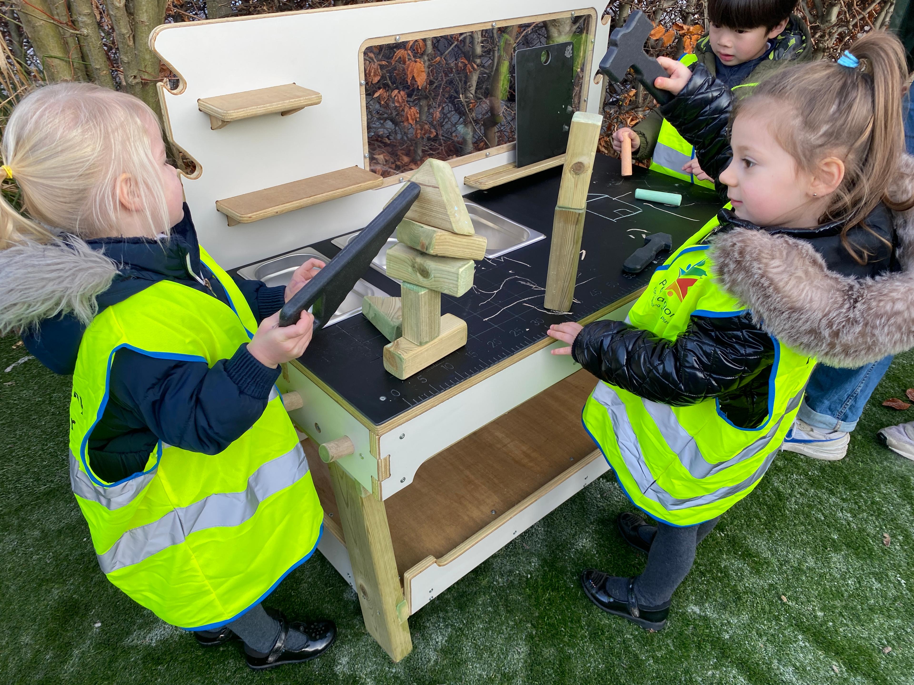 2 young girls playing on the construction table