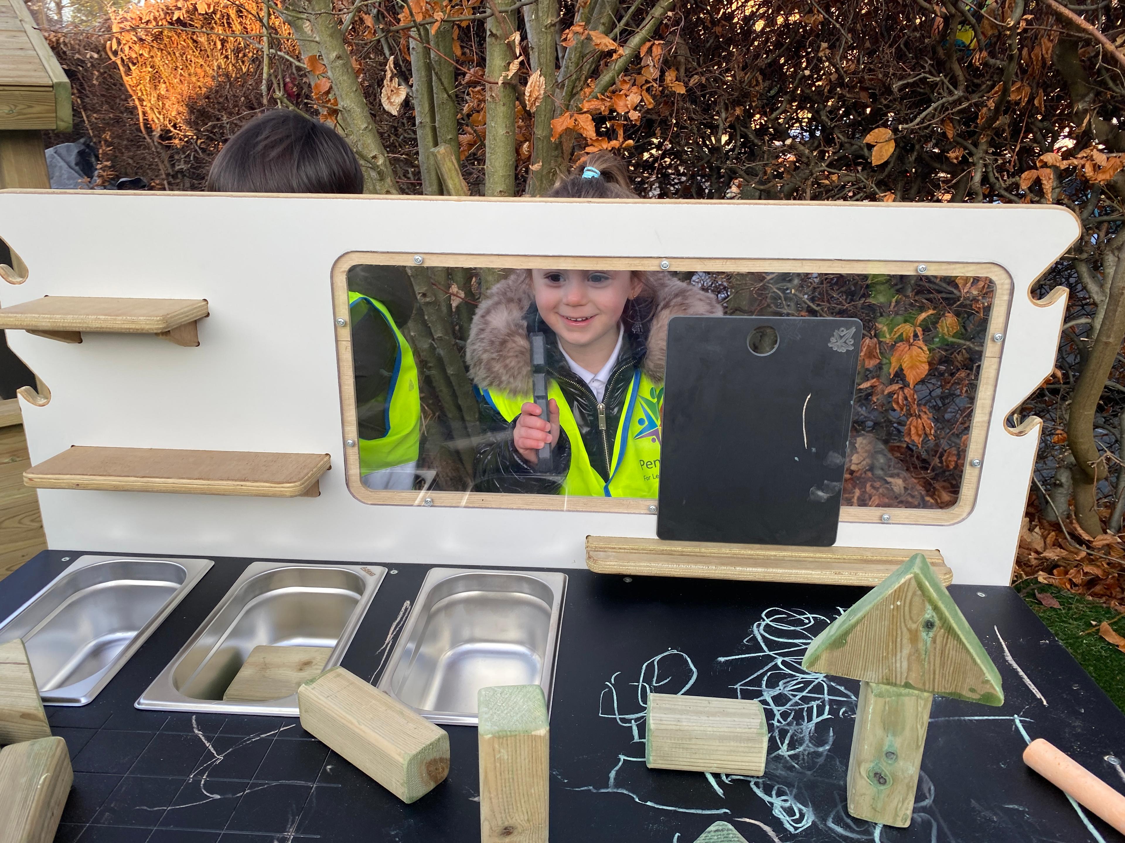 A young girl looking through the glass screen on her construction table