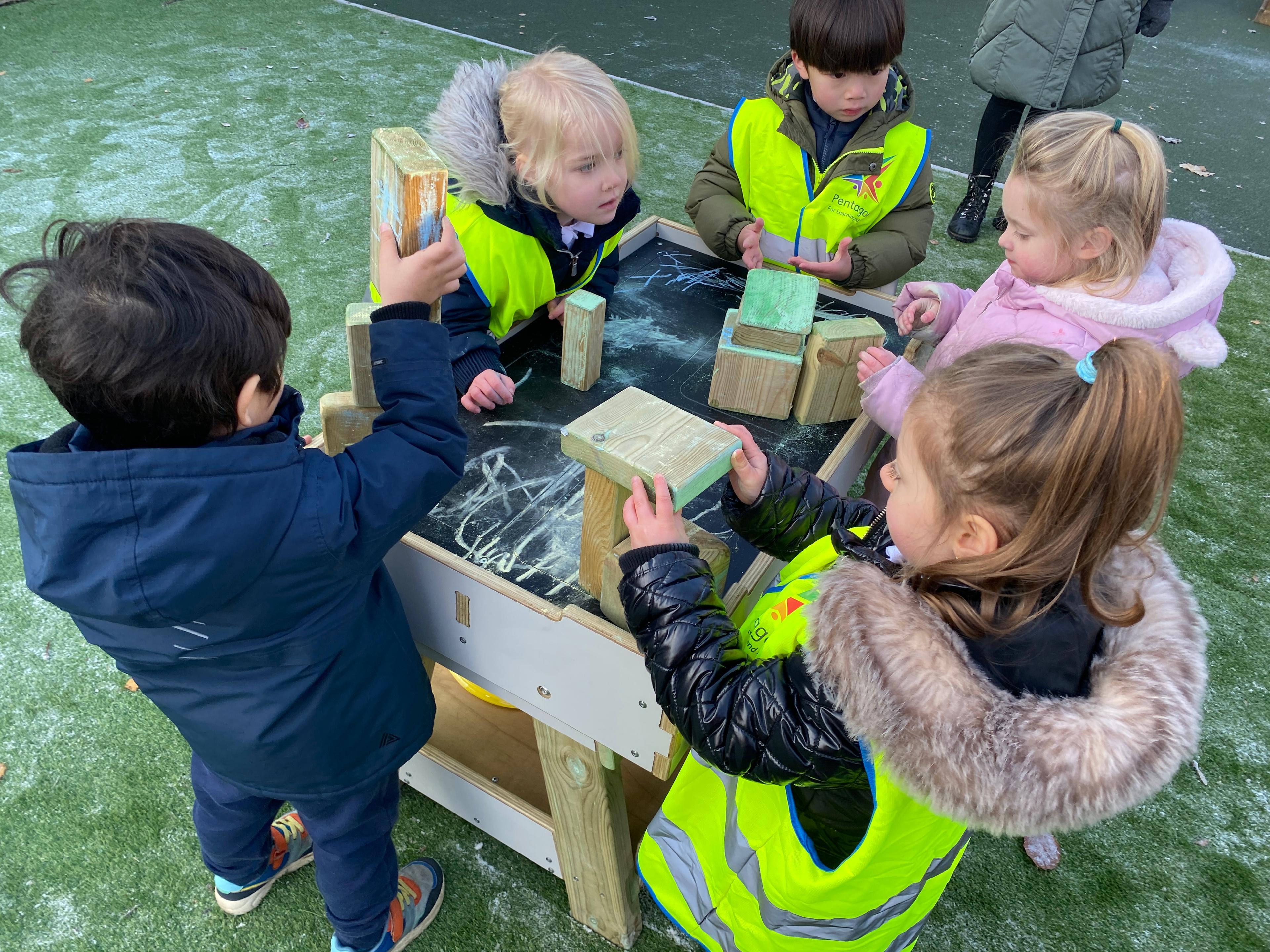 A class of children playing on the construction workbench in their primary school setting