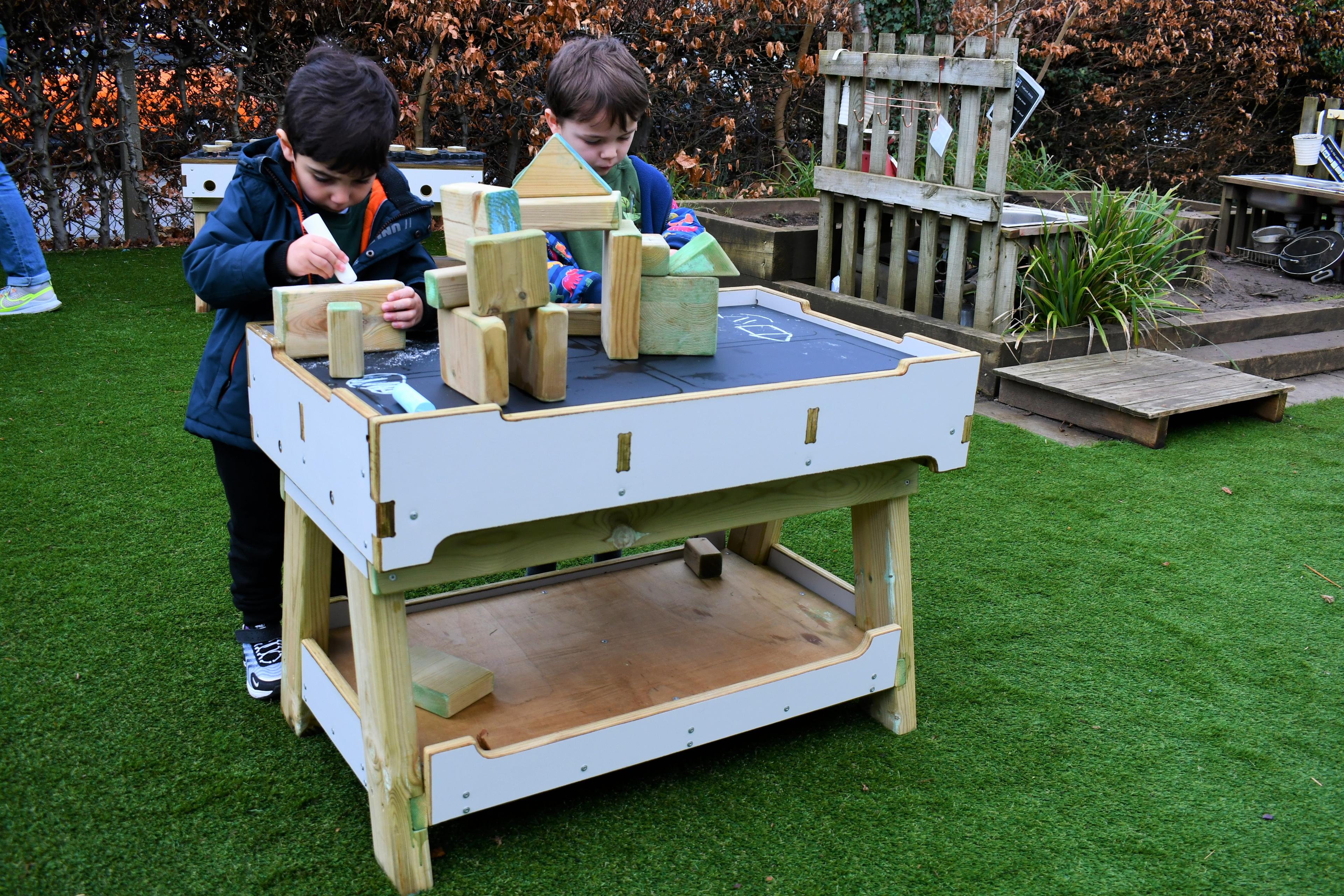 2 young boys playing on the workbench