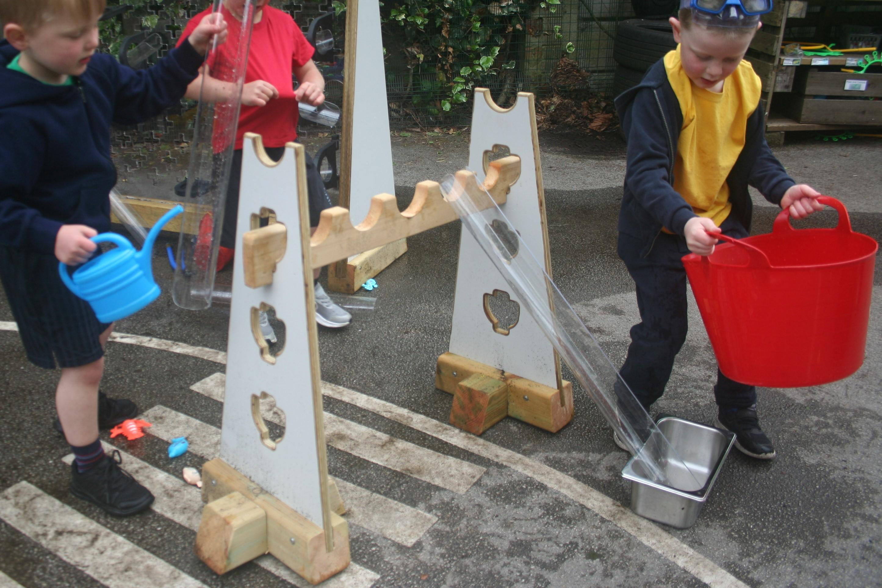 Children playing with the water channels and placing them on the water channel stands