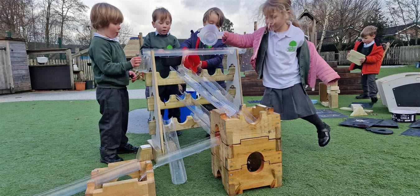 A group of children using the water channels in their playground