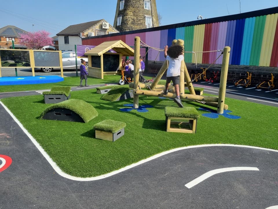 A class of children playing on the blocks in their playground