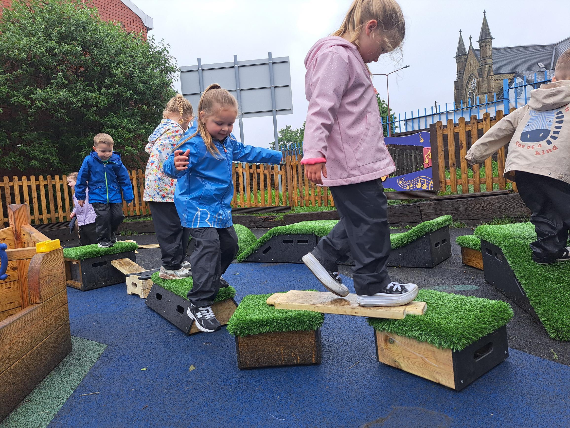 Nursery children walking over the planks and blocks included in the Sports Premium Adventurer Package