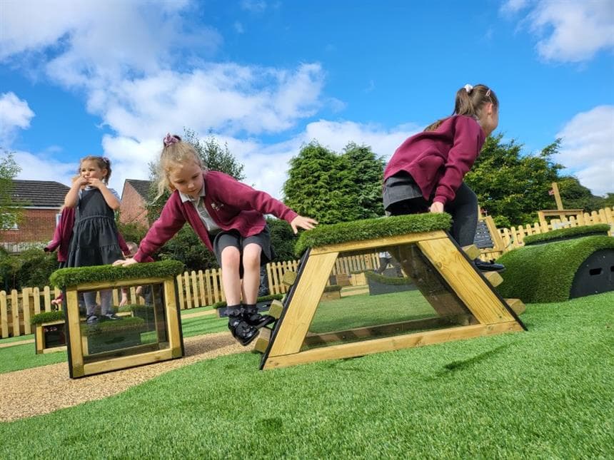 A class of children walking over the blocks in their playground