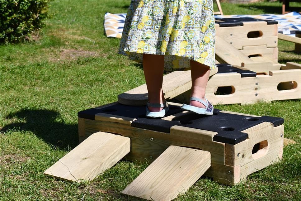 A close up picture of the planks on the side of the blocks and a girl walking up the planks