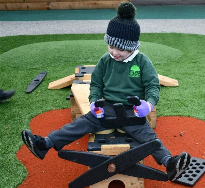 A young boy pretending to be on an aeroplane on the play builder set 