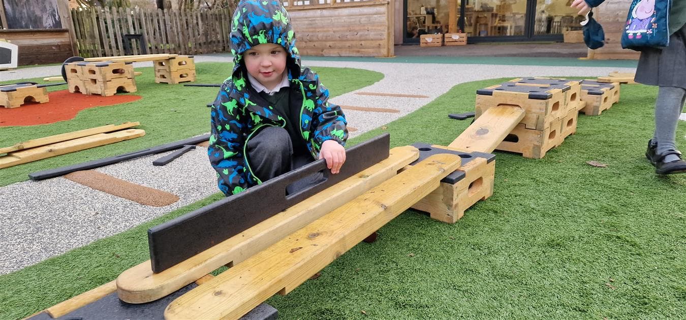 A young boy using a measurer to measure his role play playground equipment
