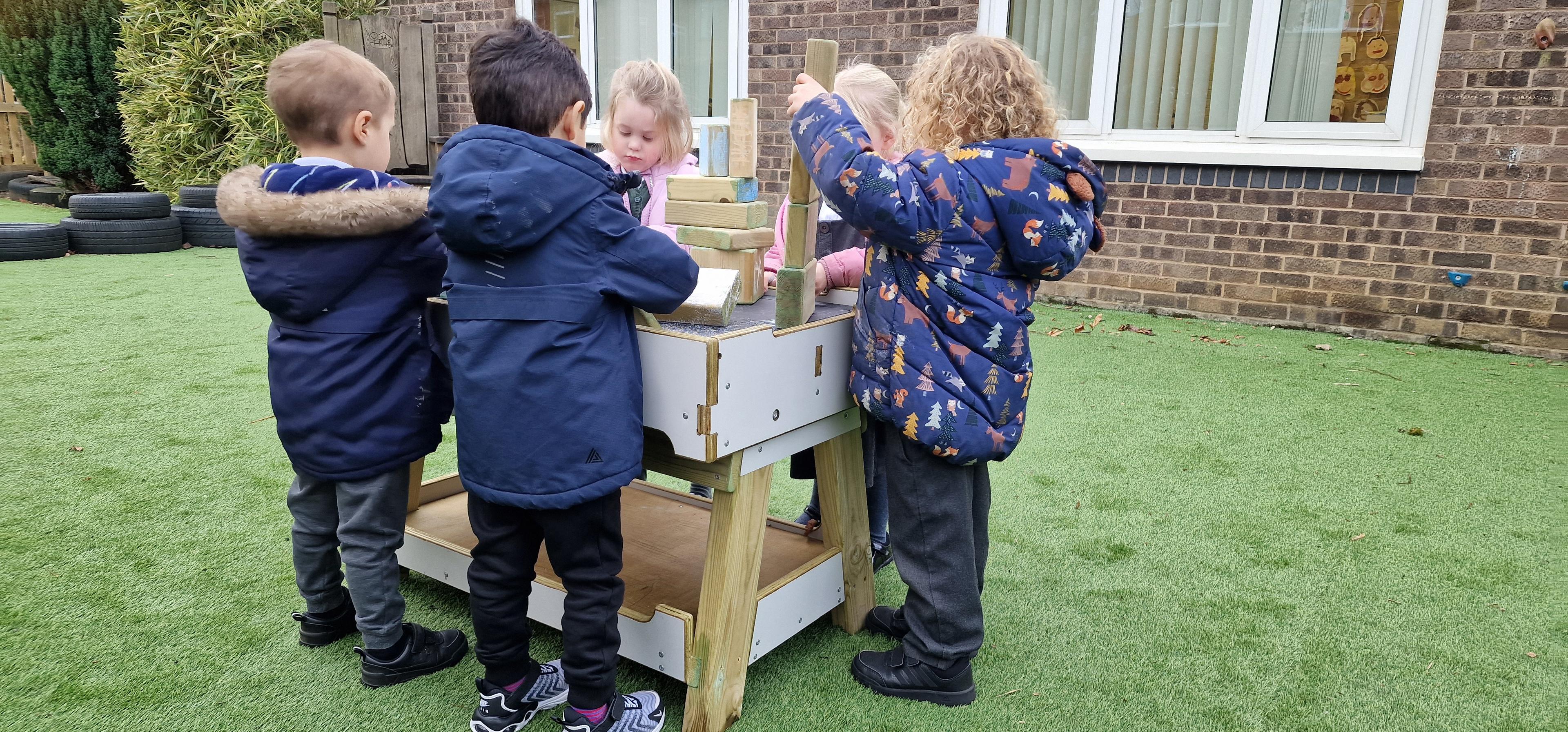 a class of children playing on the construction bench