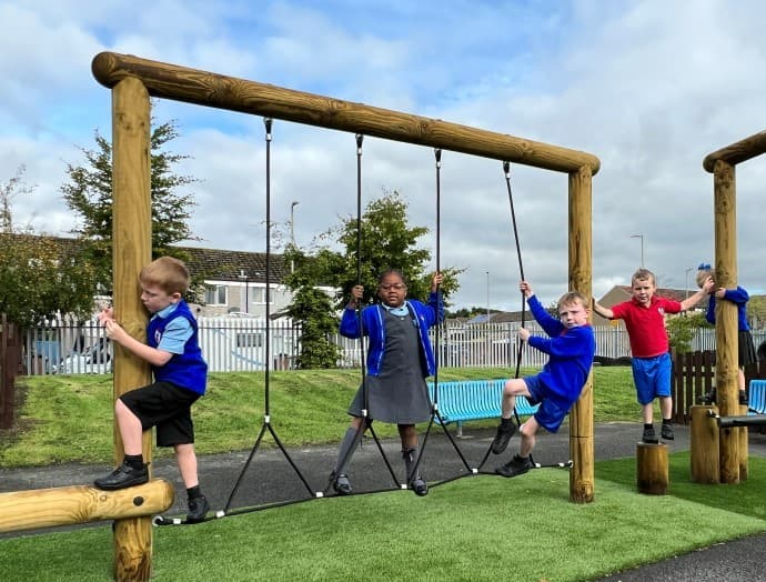 A group of children playing on the trim trail equipment