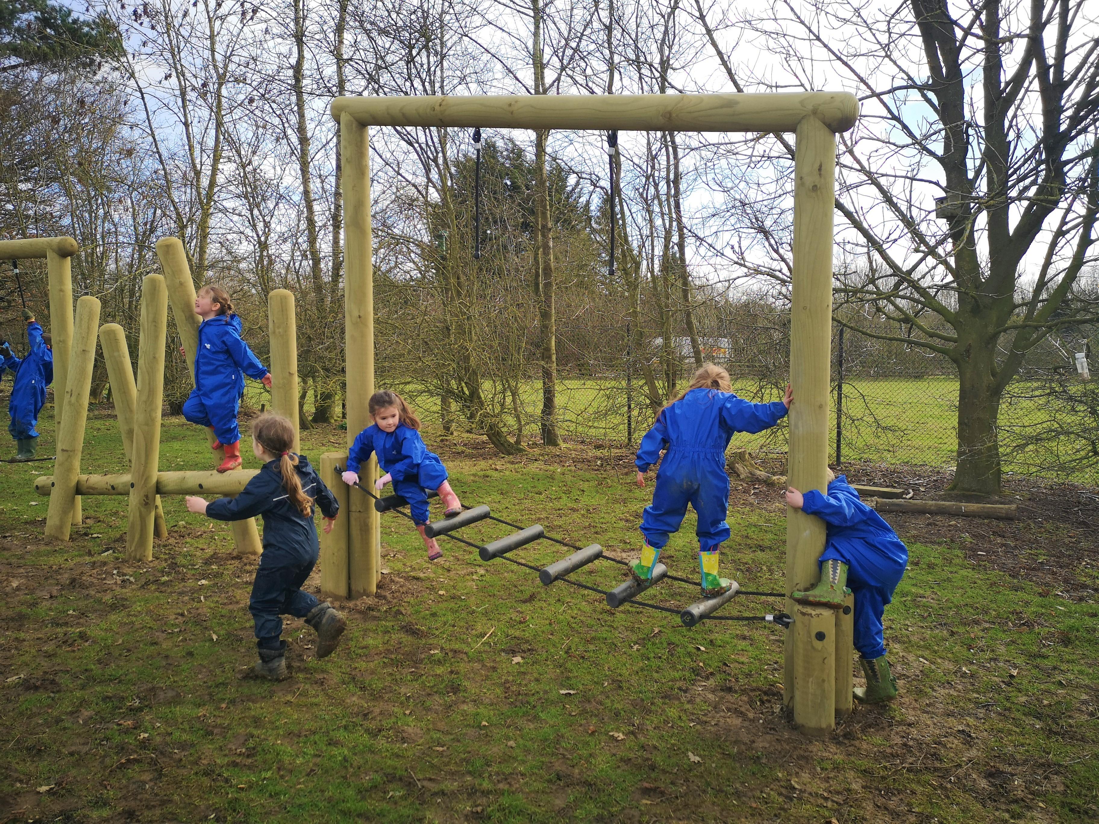 A class of children playing on their forest trim trail