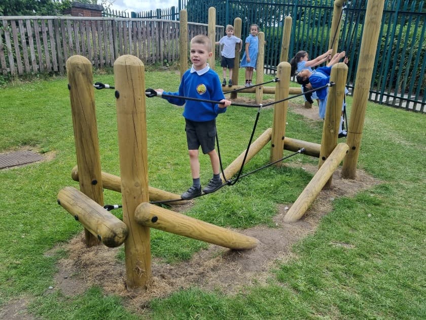 A boy balancing on the tight rope bridge