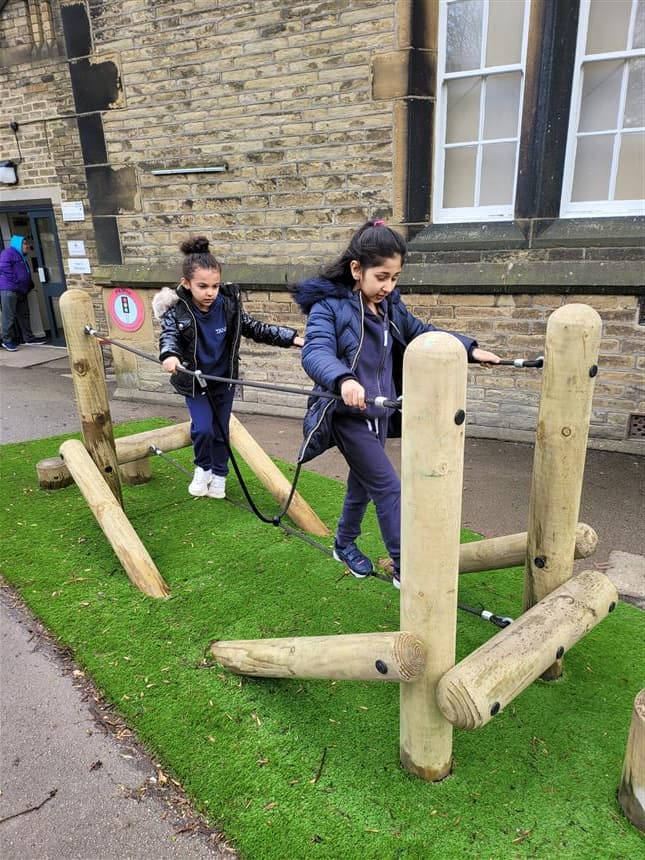 2 girls walking across the tight rope bridge