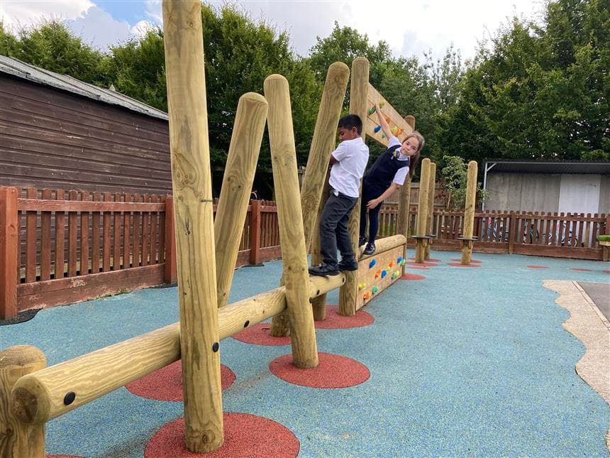 Children climbing across the climbing wall in their playground