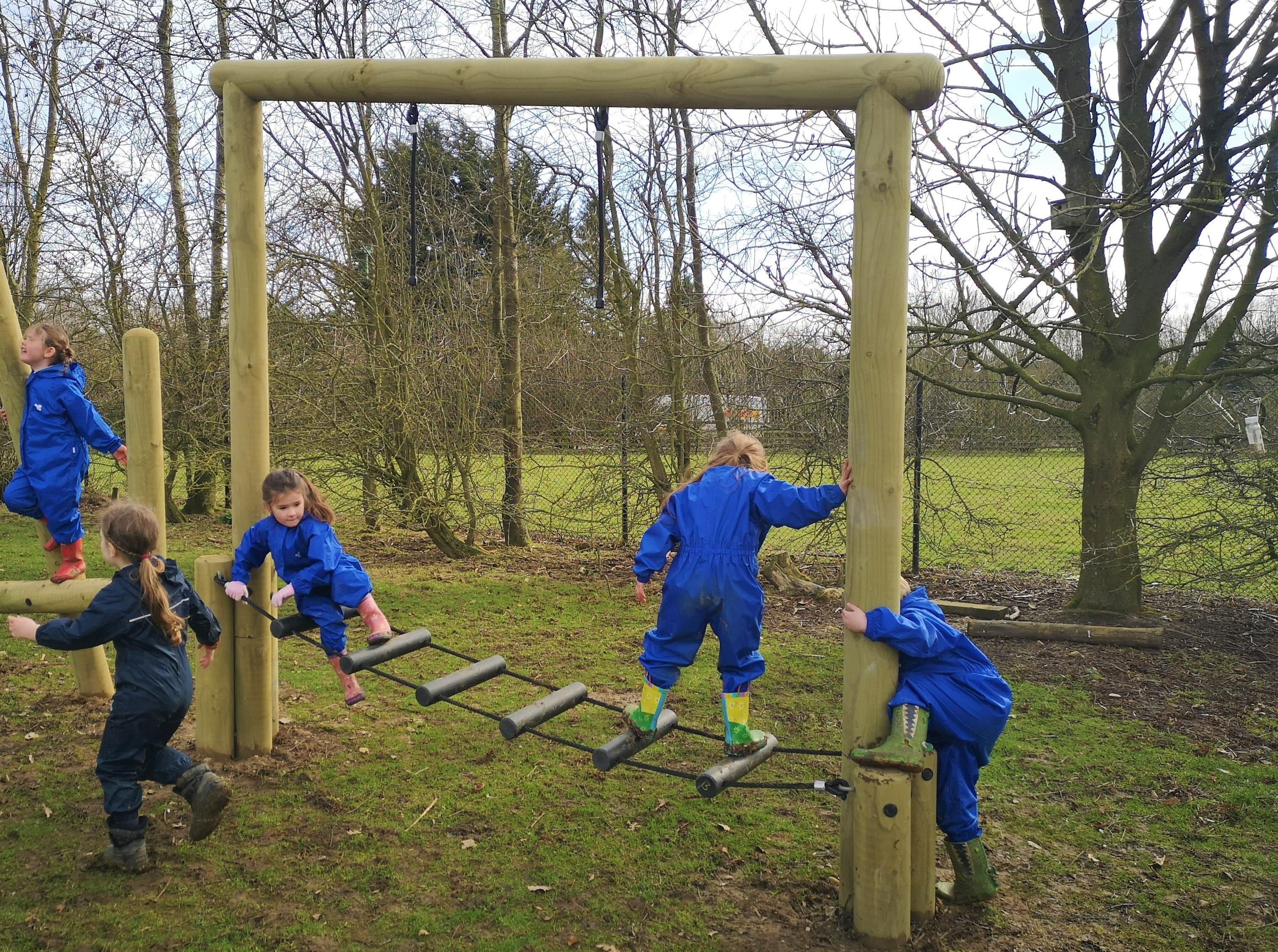 Children climbing across the clatter bridge on their trim trail