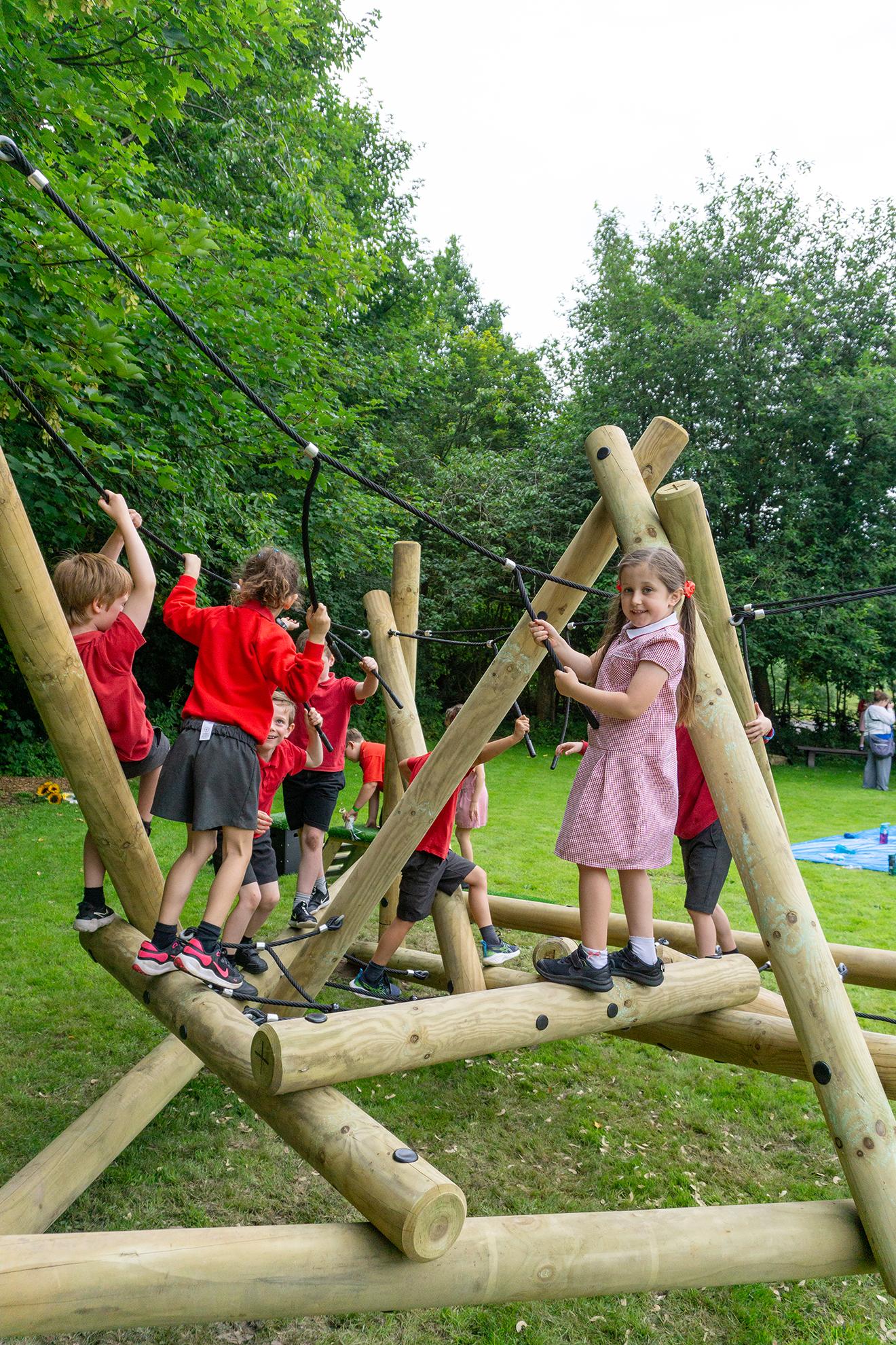 A group of girls and boys are playing together on the Latrigg Mountain Climber.