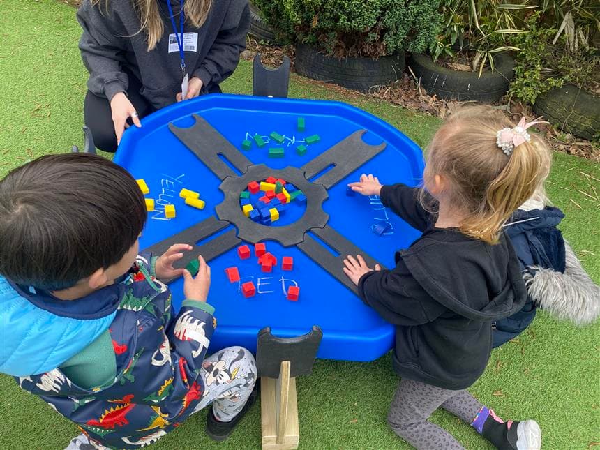 A group of children playing in the tuff spot tray in their schools