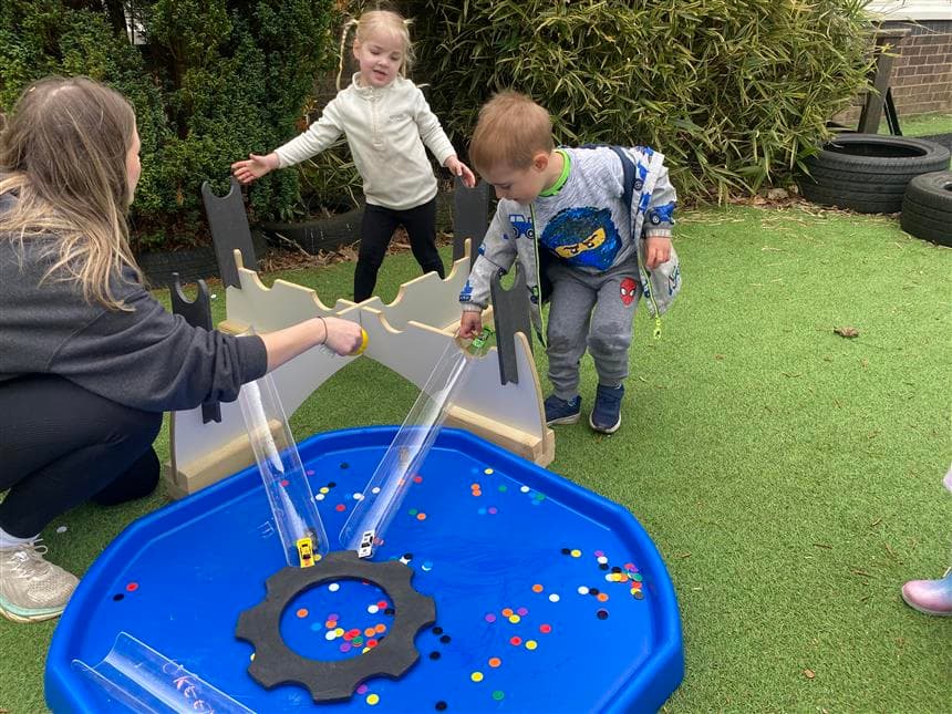 2 young children playing with the movable tuff spot tray