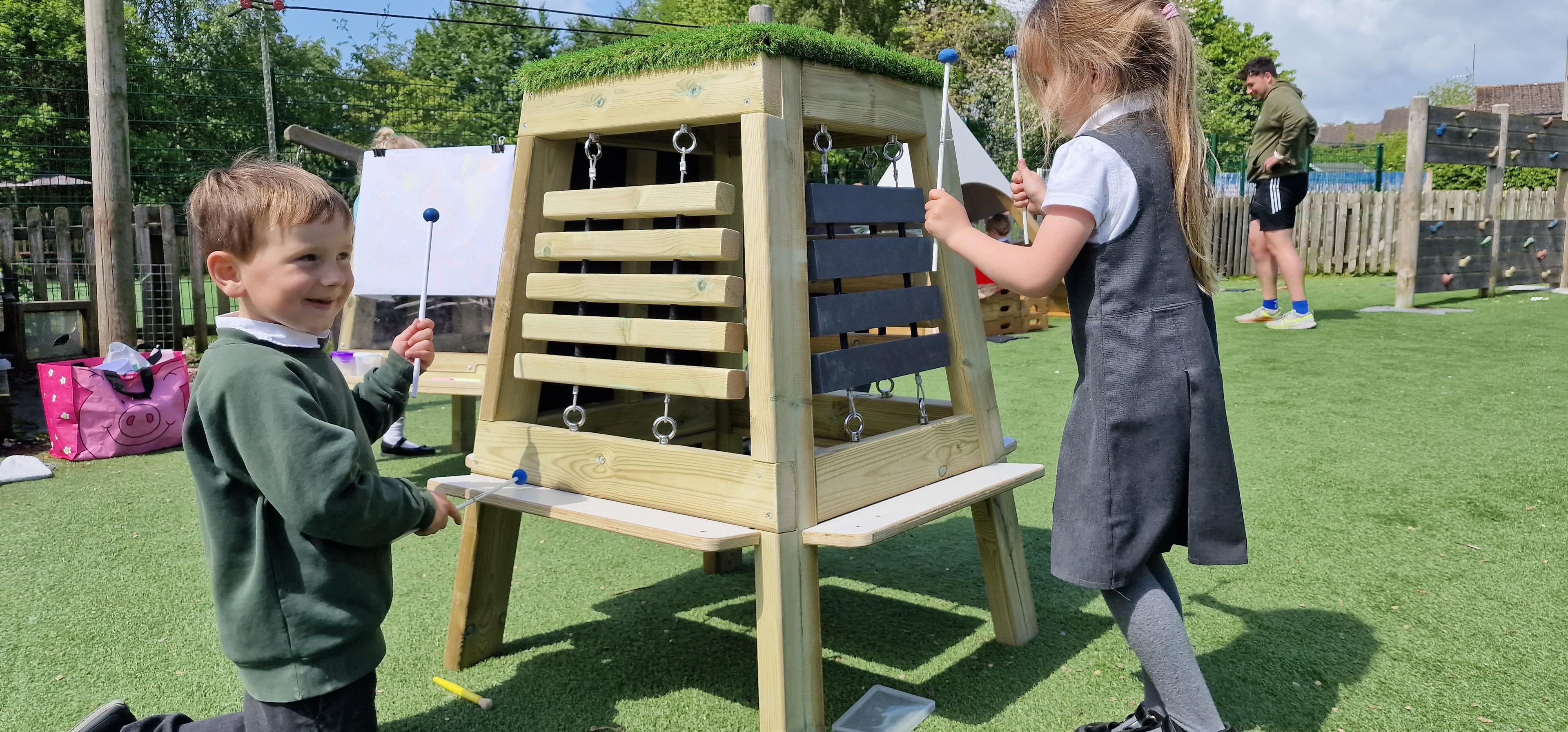 2 children playing music on the group music easel 