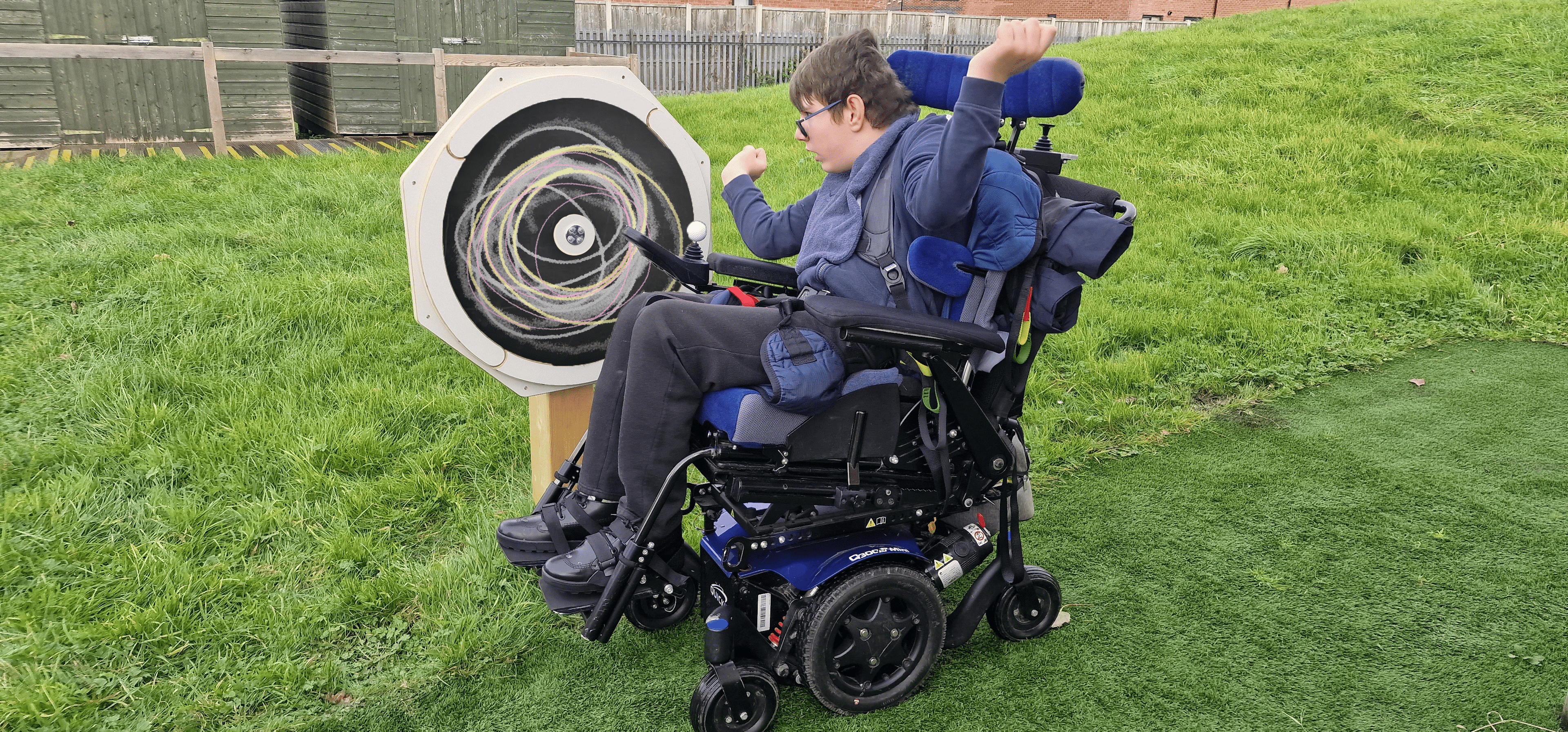 A child in a wheel chair drawing on our chalkboard sensory spinner