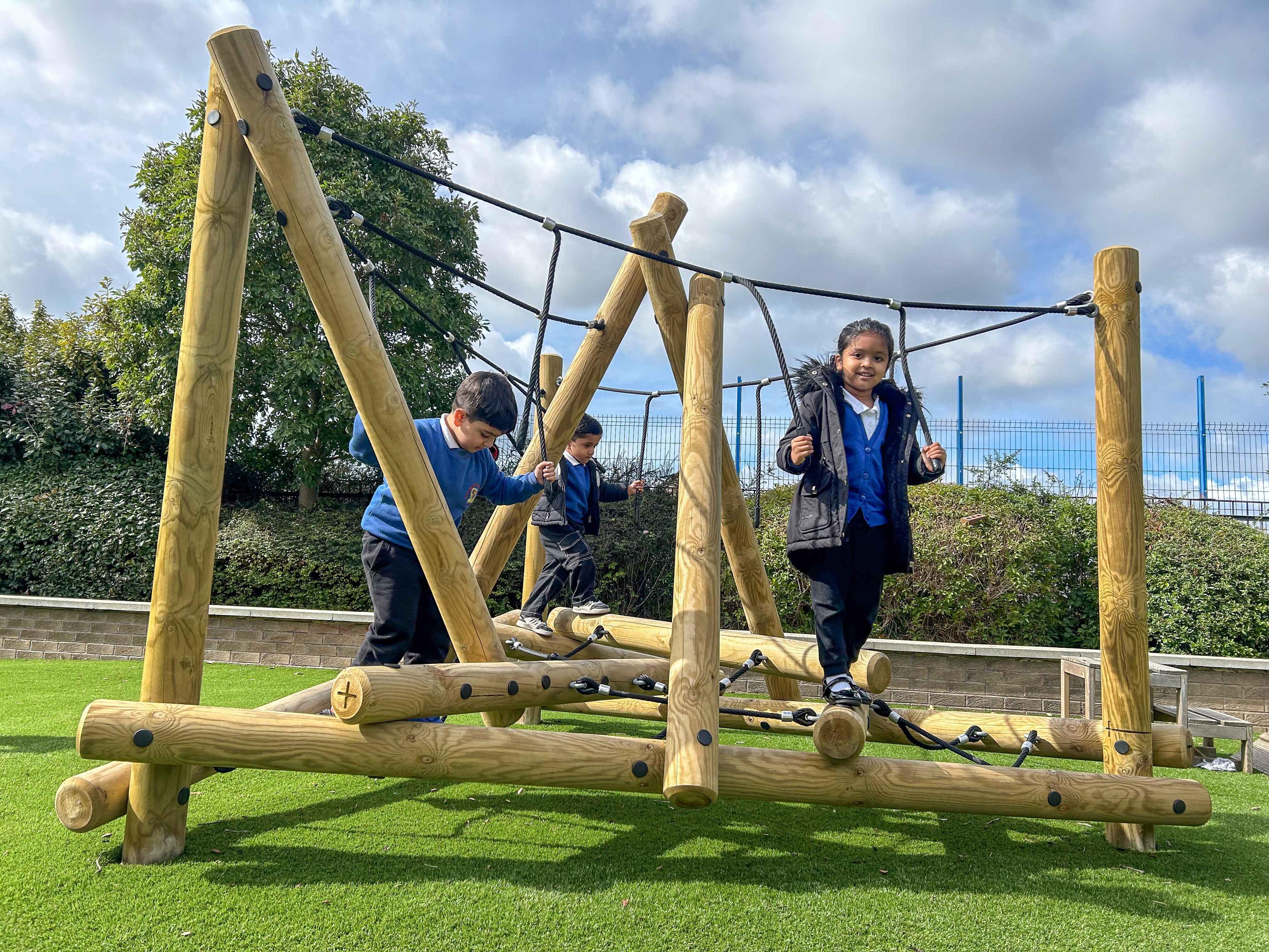 Three children are posing on the Mam Tor Climber.