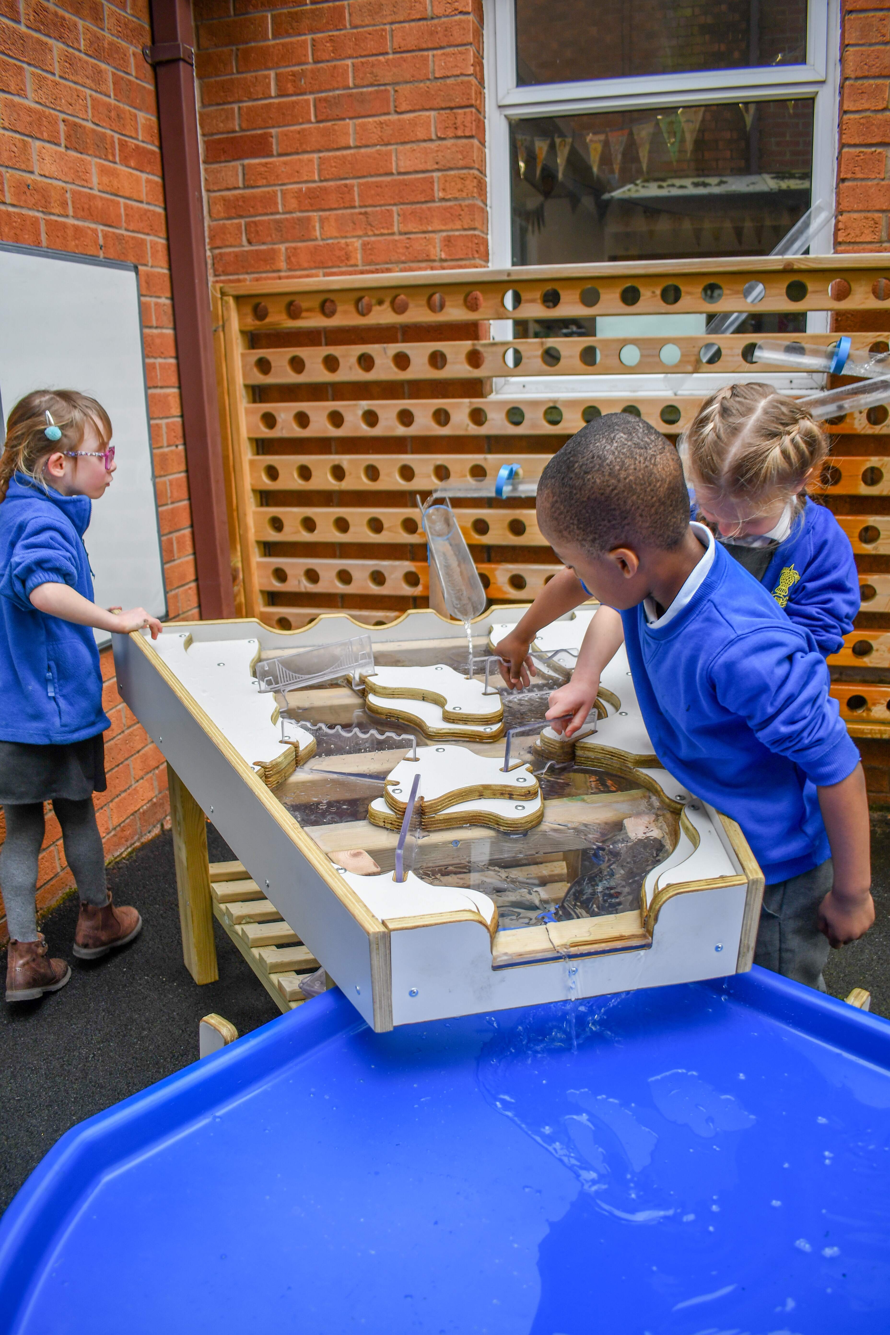 Children using mud sand and water to play on our damming station